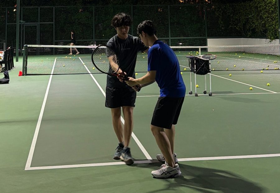 A coach correcting a student's grip in a private class